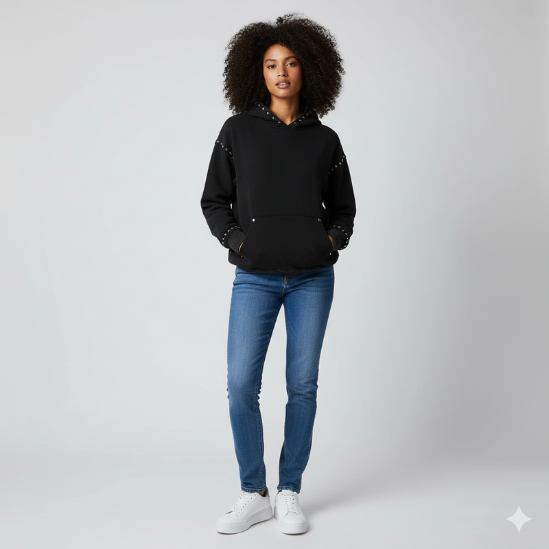 Female model wearing the Nite Owl Nite Fall black studded hoodie, a premium unisex streetwear loungewear piece featuring metal accents, oversized cozy fit, and minimalist urban design—ideal for shoppers searching for luxury women’s hoodies, elevated casual outfits, and modern everyday streetwear essentials.